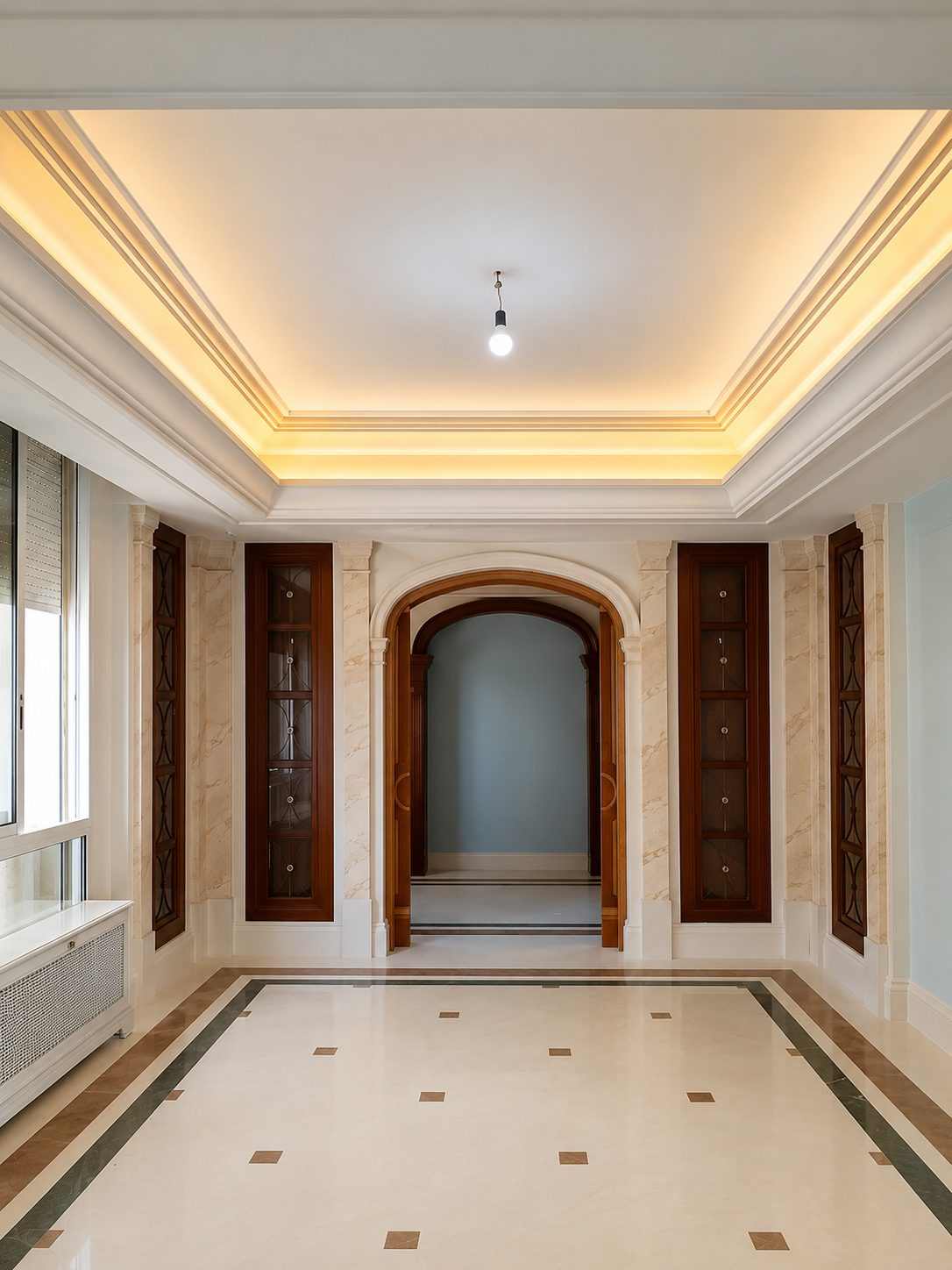 Marble entrance hall with warm cove lighting and arched doorway, completed by Rita (SL) Ltd